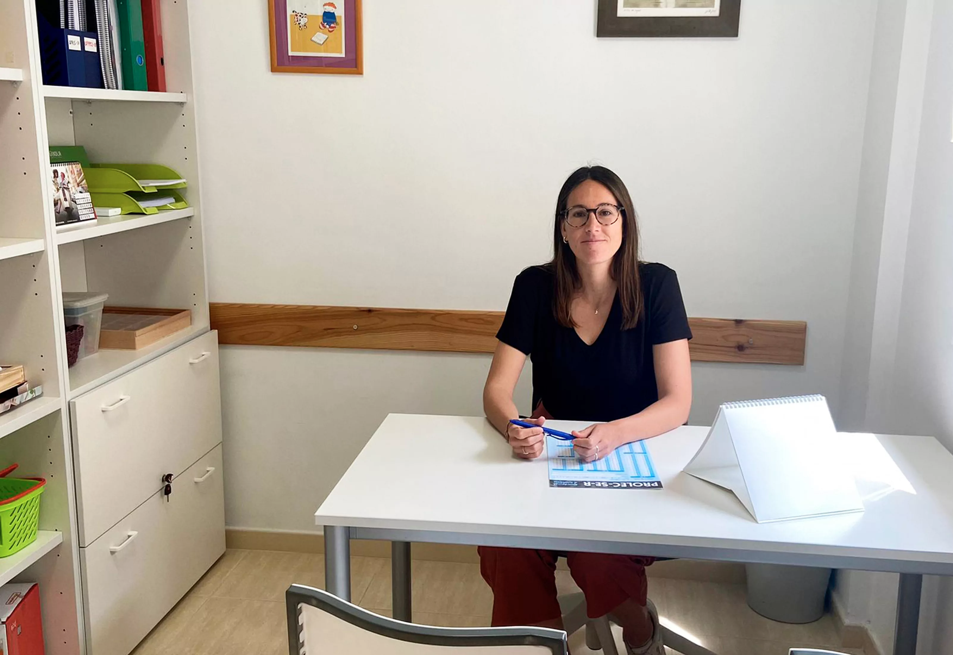 Terapeuta de Bruixola Figueres sentada en su despacho, lista para atender a un paciente